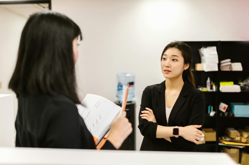 Coworkers communicating in a Korean office using business terms and abbreviations